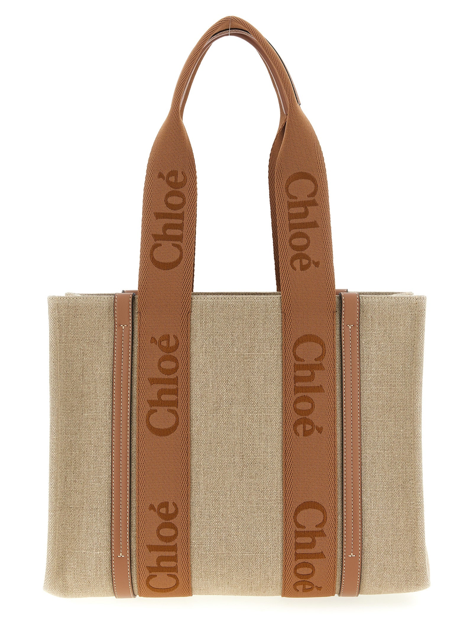 Chloé Woody medium tote bag in natural linen canvas featuring dusty tan shiny calfskin leather strips and matching embroidered logo webbing ribbons from The Exclusive Line Singapore.