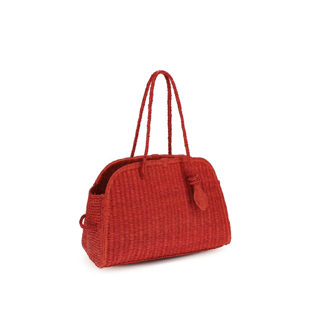 Side view of Jacquemus Le Turismo red basket-weave raffia bowling bag with tied bow detail, available at The Exclusive Line Singapore.