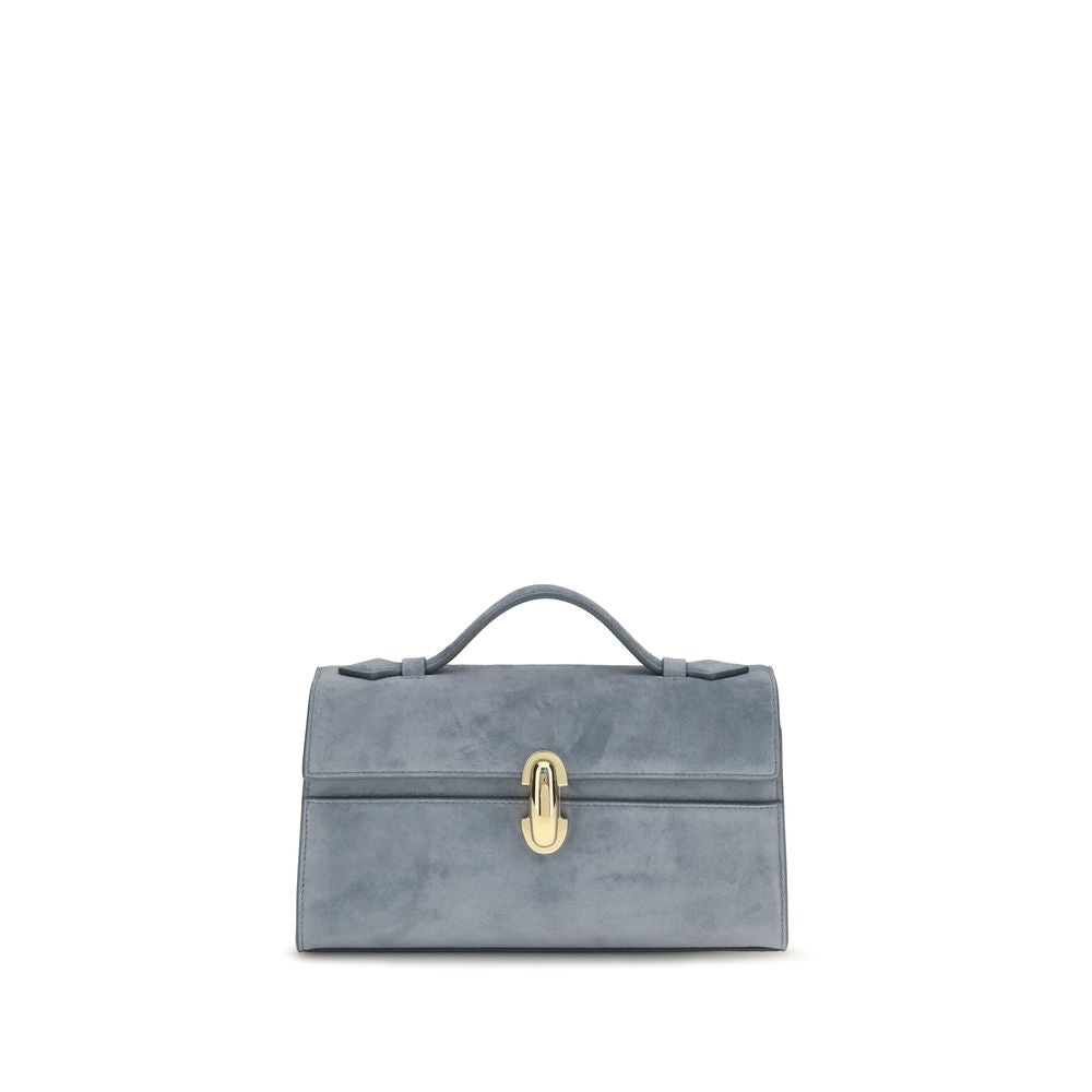 Savette Symmetry Pochette bag in denim blue suede, featuring a minimalist rectangular silhouette, leather top handle, and signature polished turnlock closure.