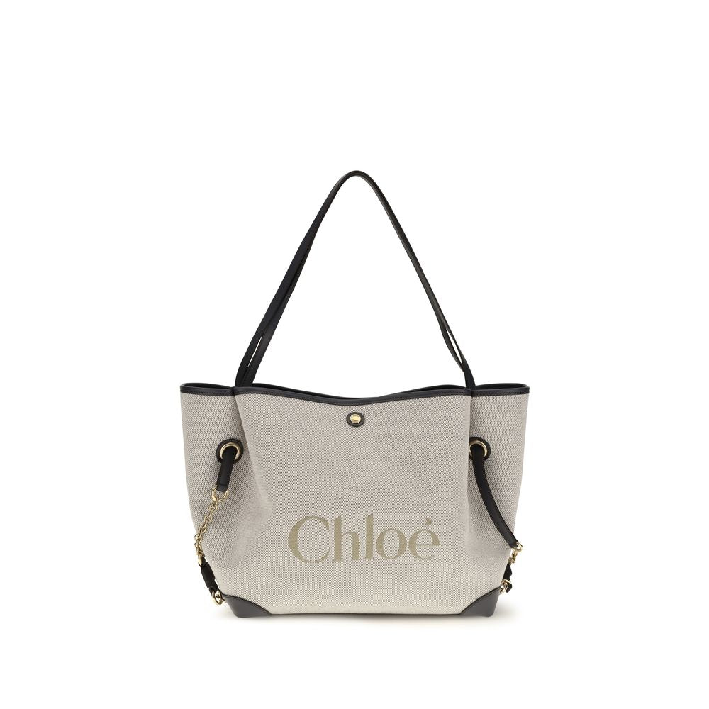 Chloé Clover double carry bag in black navy cotton canvas featuring a spacious silhouette, an oversized Chloé logo, brown calfskin trim, and gold-tone hardware from The Exclusive Line Singapore.