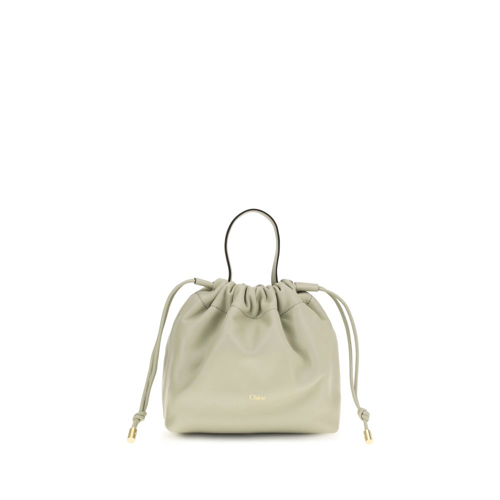 Chloé Icons small shoulder bag in cloudy cream nappa lambskin featuring a fluid drawstring closure and a gold-tone charm chain with a signature Horse Medal from The Exclusive Line Singapore.