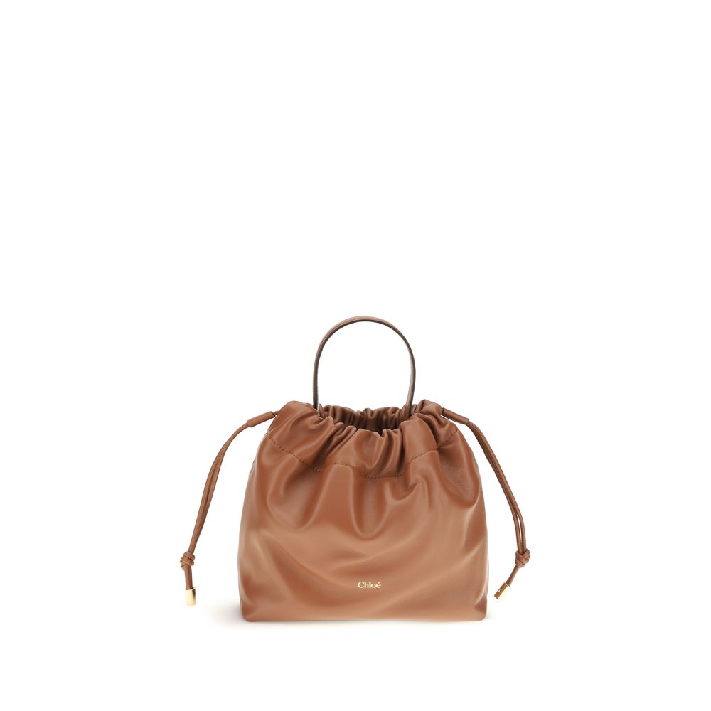 Chloé Icons small shoulder bag in tan nappa lambskin featuring a drawstring closure and a gold-tone charm chain with a signature Horse Medal from The Exclusive Line Singapore.