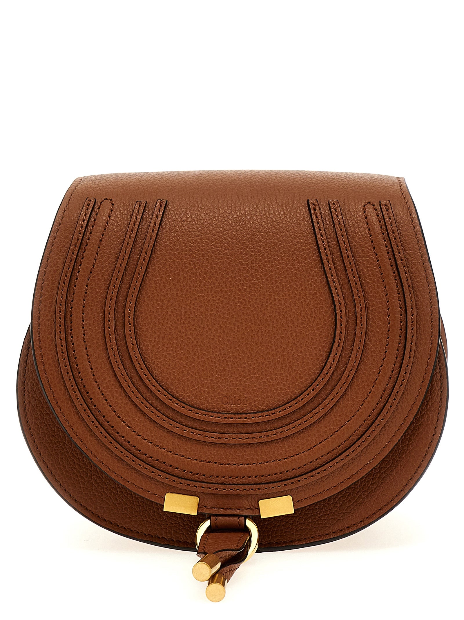 Chloé Marcie small saddle bag in tan grained calfskin leather featuring signature saddle stitching, hanging tassel, and antique gold hardware from The Exclusive Line Singapore.