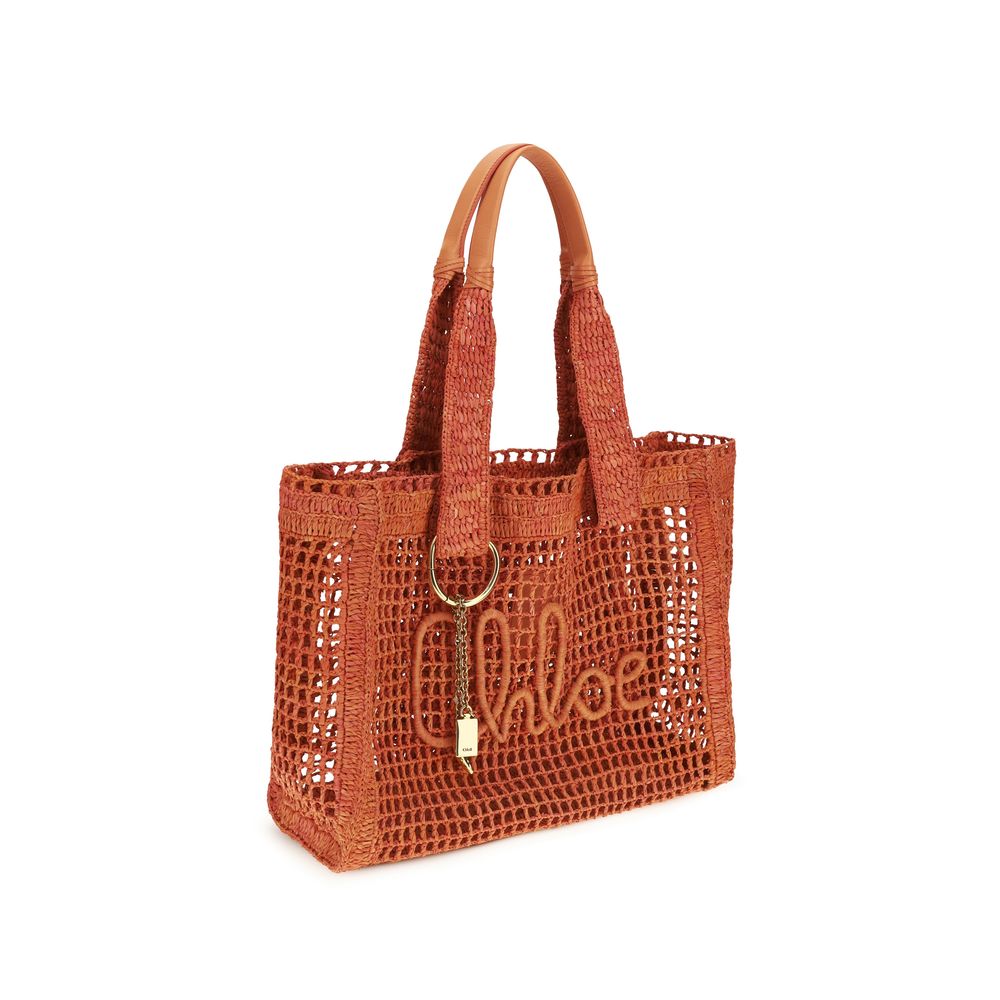 Side view of Chloé Summer Banana East-West Tote Bag in Raffia in Clay Brown from The Exclusive Line Singapore.
