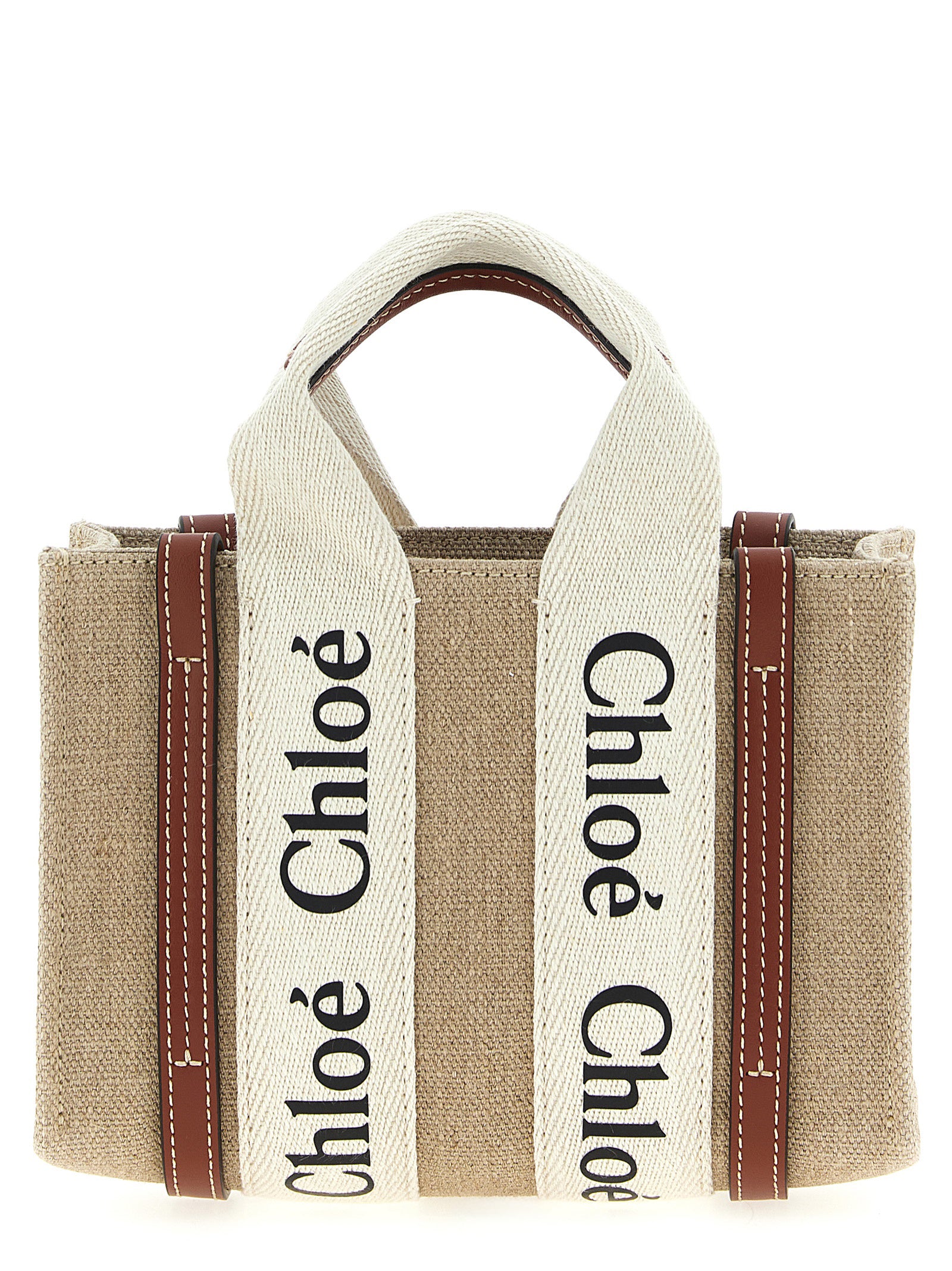 Chloé Woody mini tote bag in white linen canvas featuring rich brown shiny calfskin leather strips and the signature black-and-white logo ribbon from The Exclusive Line Singapore.