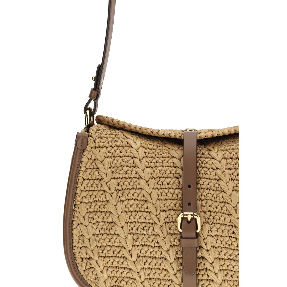 Close-up of the Etro gold-finish Pegaso coin magnetic closure and buckle on brown raffia texture.