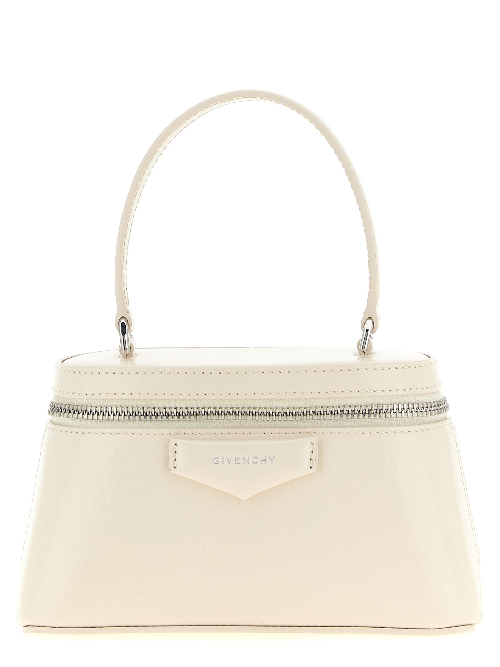 Givenchy Antigona Vanity Bag in cream box calfskin leather featuring a pentagonal patch with silver-finish embossed signature and a chain crossbody strap.
