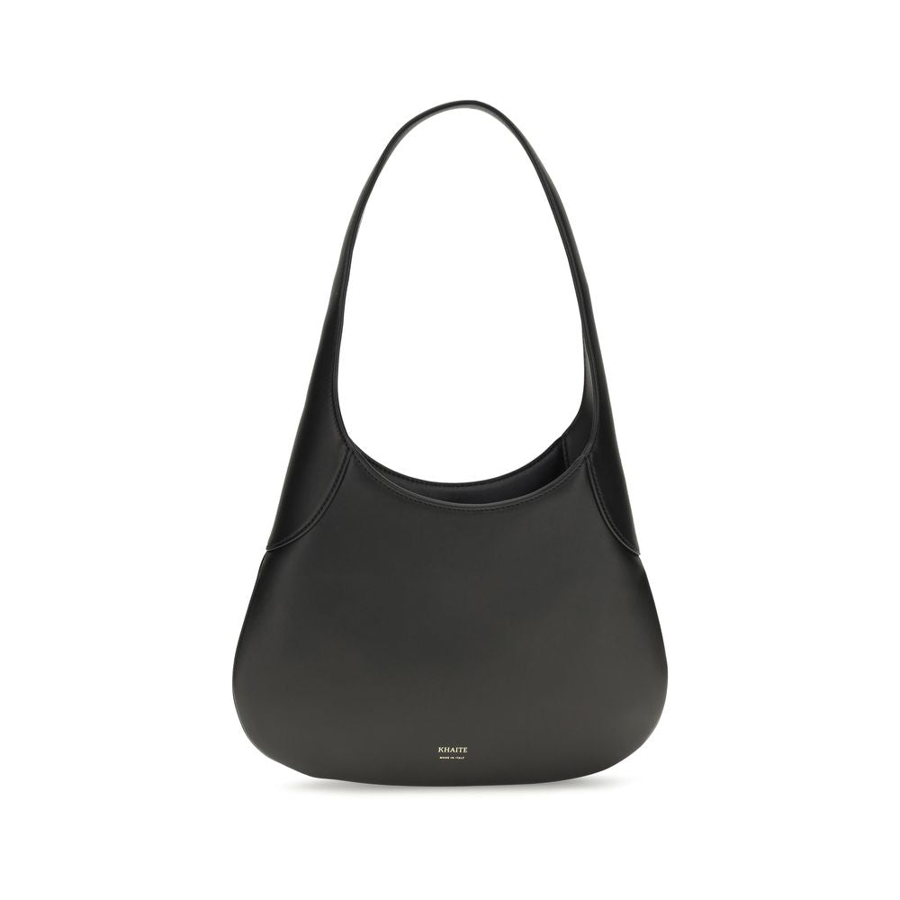 Profile view of the black Khaite Joan Small Hobo Bag made of smooth calfskin leather, showcasing its slouchy silhouette and integrated strap.