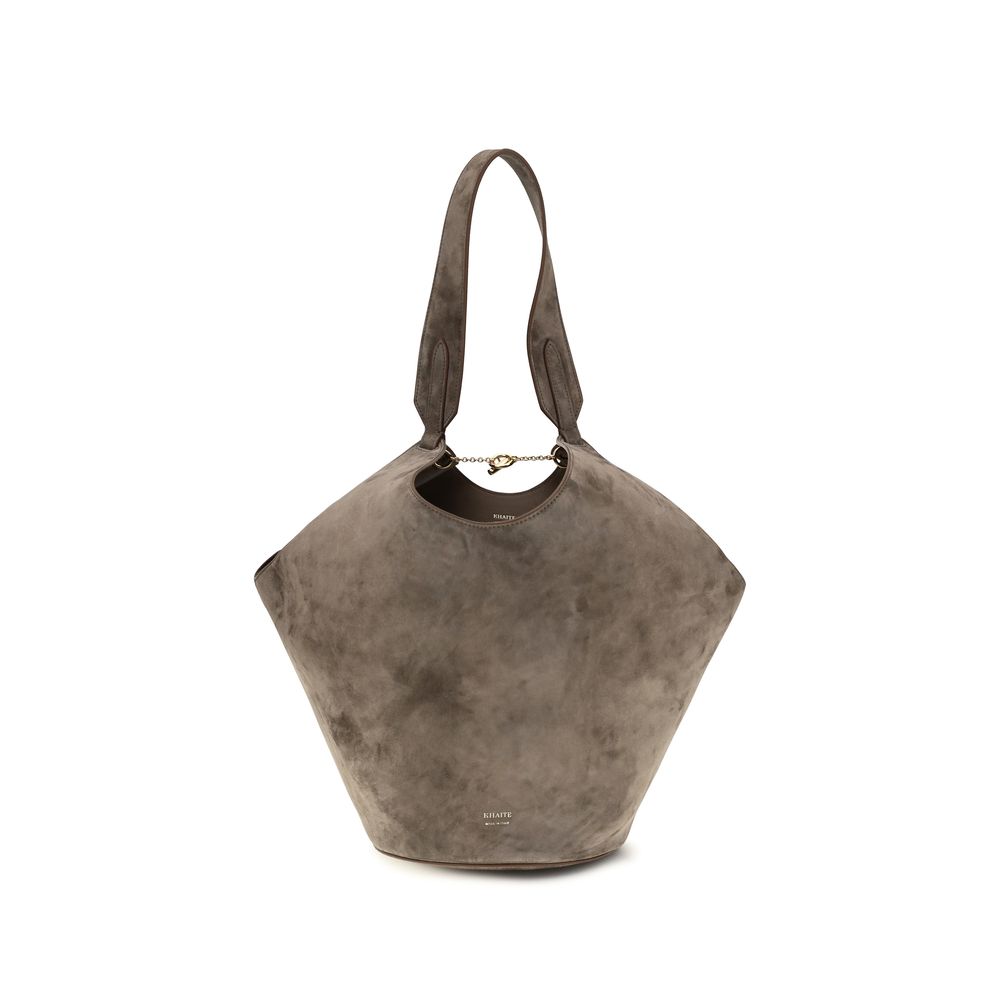 Khaite Small Lotus Tote in velvety cedar suede, featuring a unique fluid draped scarf-inspired shape with an integrated top handle and a stable round base.