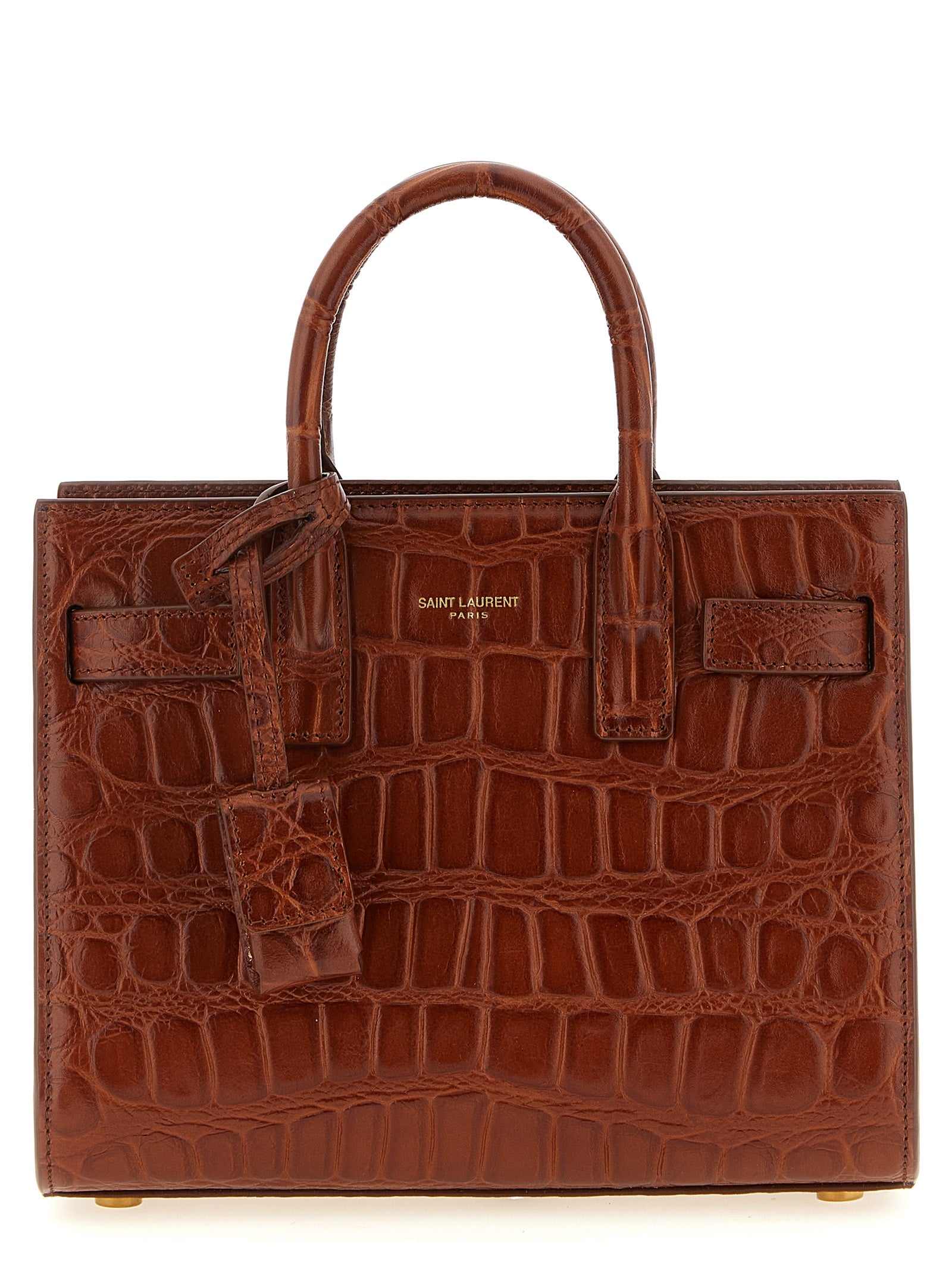 Saint Laurent Sac de Jour Nano tote bag in cognac crocodile-embossed leather featuring tubular top handles and a hanging bronze padlock charm case from The Exclusive Line Singapore.