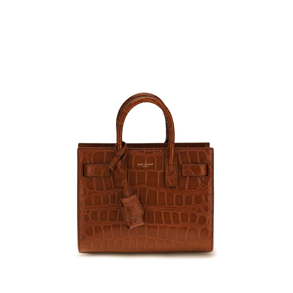 Saint Laurent Sac de Jour Nano in black crocodile-embossed leather featuring accordion sides, top handles, and bronze-tone padlock.