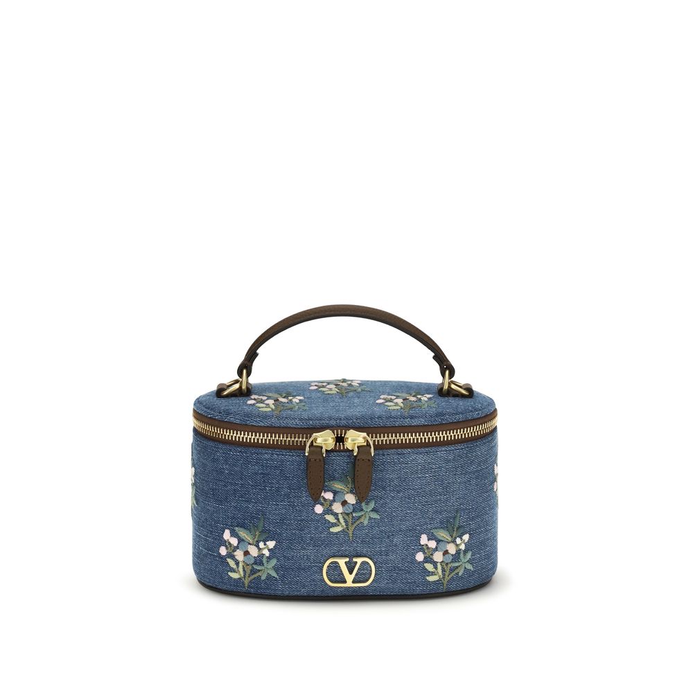 Valentino Garavani VLogo Signature mini vanity bag in denim with blue and white floral embroidery, antique brass hardware, and brown leather top handle.